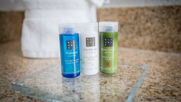 Three bottles of hair care products on a granite countertop.