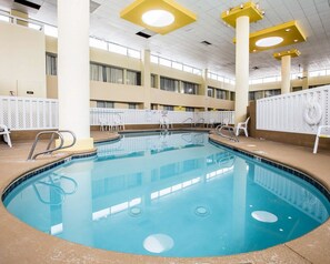 Relax by the oval-shaped pool surrounded by comfortable lounge chairs and a clean, well-lit deck.