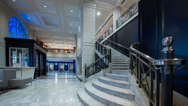 A spacious lobby with marble flooring, a staircase, and a reception desk. - Novotel Toronto Centre (Toronto)