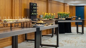 A buffet setup with various food items, a wooden panel wall, and a blue accent wall. - Novotel Toronto Centre (Toronto)