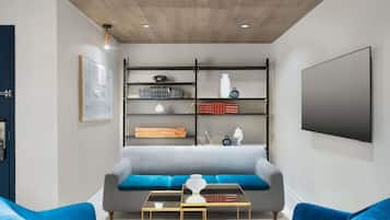 Ein modernes Wohnzimmer mit einer Couch, zwei Sesseln, einem Couchtisch und einem Bücherregal.