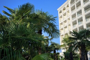 Un hotel de varios pisos con fachada blanca y balcones.