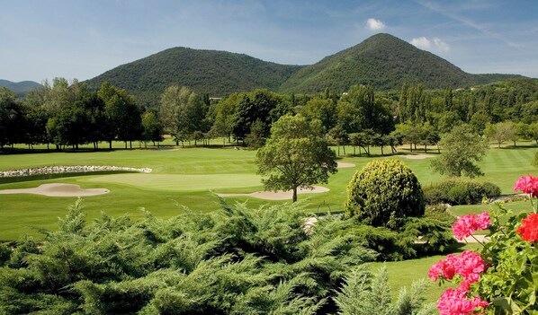 A golf course with a mountain backdrop, well-maintained grass, and a variety of trees. - GRAND HOTEL TRIESTE & VICTORIA – Contemporary Thermal Luxury SPA (Abano Terme)