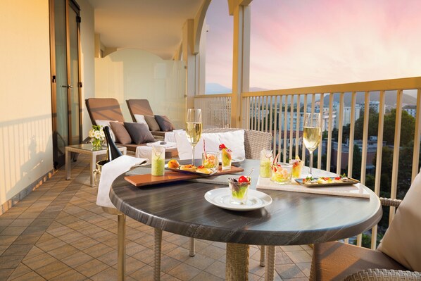 A balcony with a dining table set for two, featuring a variety of drinks and appetizers. - GRAND HOTEL TRIESTE & VICTORIA – Contemporary Thermal Luxury SPA (Abano Terme)