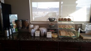 A breakfast buffet with various food items and condiments.