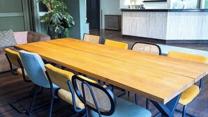 A conference room with a long wooden table, six chairs, and two pendant lights. - Coffee Fellows Hotel Frankfurt-Langen (Langen)