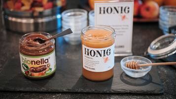 A jar of bionella chocolate spread and a jar of honig on a slate board.