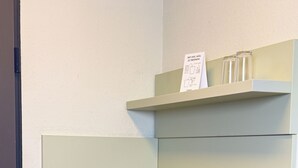A compact kitchen with a stainless steel sink, two burners, and a small shelf above the sink. - Coffee Fellows Hotel Frankfurt-Langen (Langen)