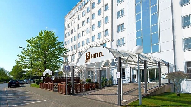 A hotel with a covered outdoor seating area and a sign indicating it is a coffee house. - Coffee Fellows Hotel Frankfurt-Langen (Langen)