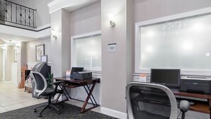 A business center with a desk, chairs, an ATM, and a computer. - Rodeway Inn & Suites Williamsburg Central (Williamsburg)
