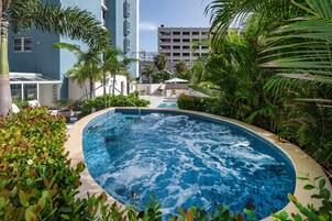 Una piscina al aire libre, sillones reclinables de piscina