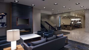 A modern lobby with a seating area, a staircase, and a Starbucks coffee station. - DoubleTree by Hilton Hotel London Ontario (London)