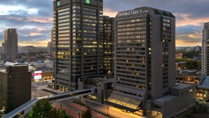 A high-rise hotel with multiple floors, a prominent entrance, and a covered area with a glass roof. - DoubleTree by Hilton Hotel London Ontario (London)