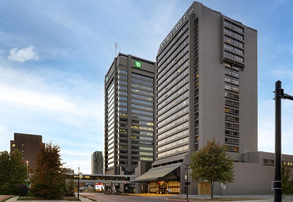 A modern hotel with a prominent 'D' logo, multiple floors, and a large entrance with a covered area. - DoubleTree by Hilton Hotel London Ontario (London)