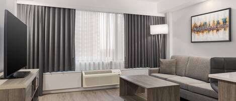 A modern living room with a flat-screen TV, a sofa, a coffee table, and a radiator.