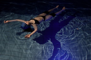 Una persona flotando en una piscina.