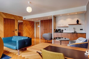 A modern living room with a blue sofa, a grey armchair, and a wooden coffee table. - Hotel Reykjavik Askja (Reykjavik)