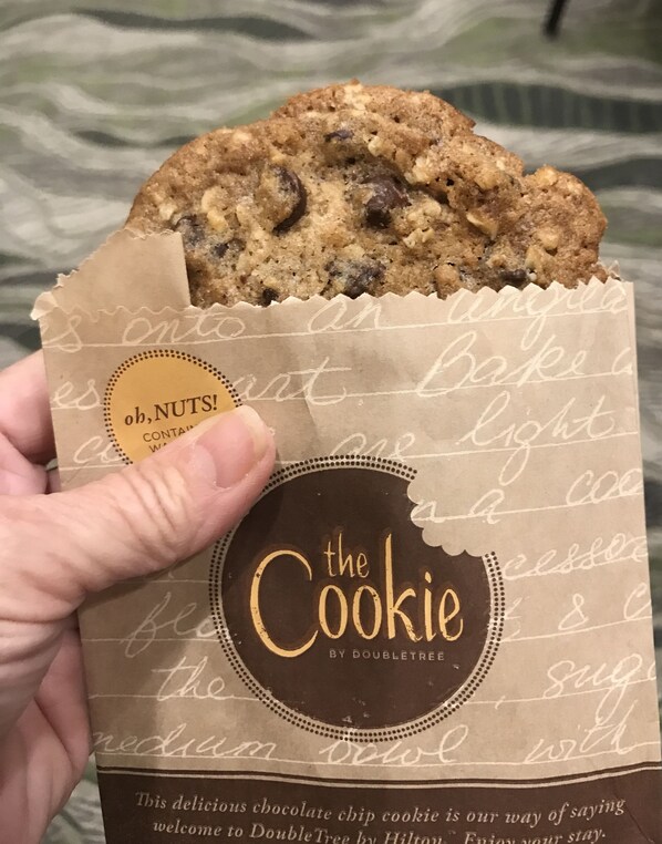 A hand holding a cookie package with a handwritten note.