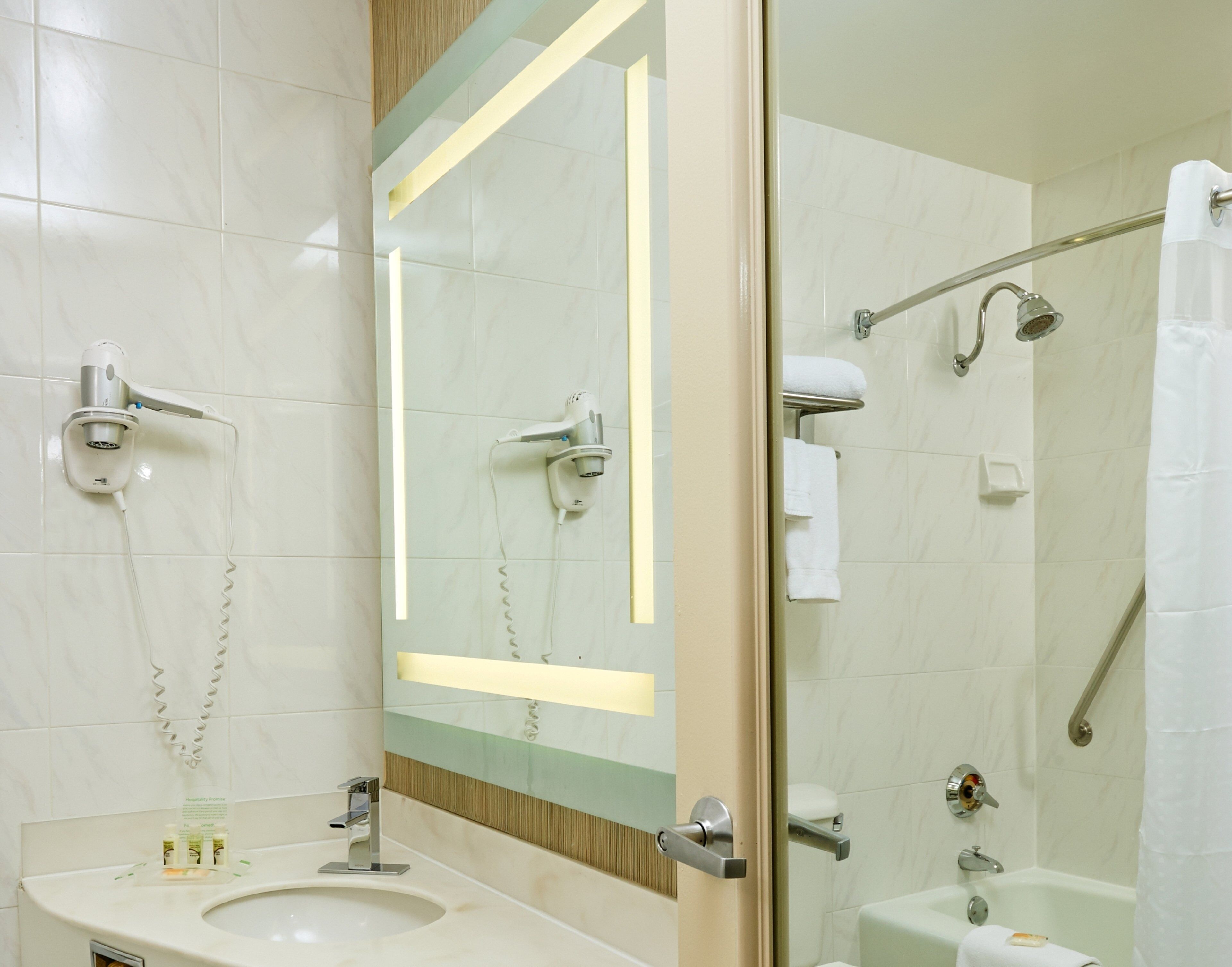 A modern bathroom with a sink, mirror, and shower.