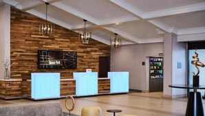 Un hall de hotel con mostrador de recepción, zona de estar y minibar.
