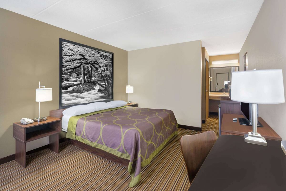Une chambre d’hôtel comprenant un lit, des tables de chevet, un bureau et une chaise.