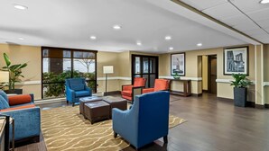 A hotel lobby with seating areas, a reception desk, and artwork on the walls. - Comfort Inn & Suites Somerset - New Brunswick (Somerset)