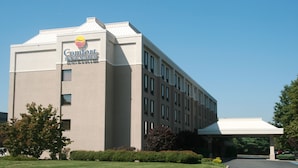 A Comfort Inn & Suites building with a flat roof, multiple windows, and a covered parking area.