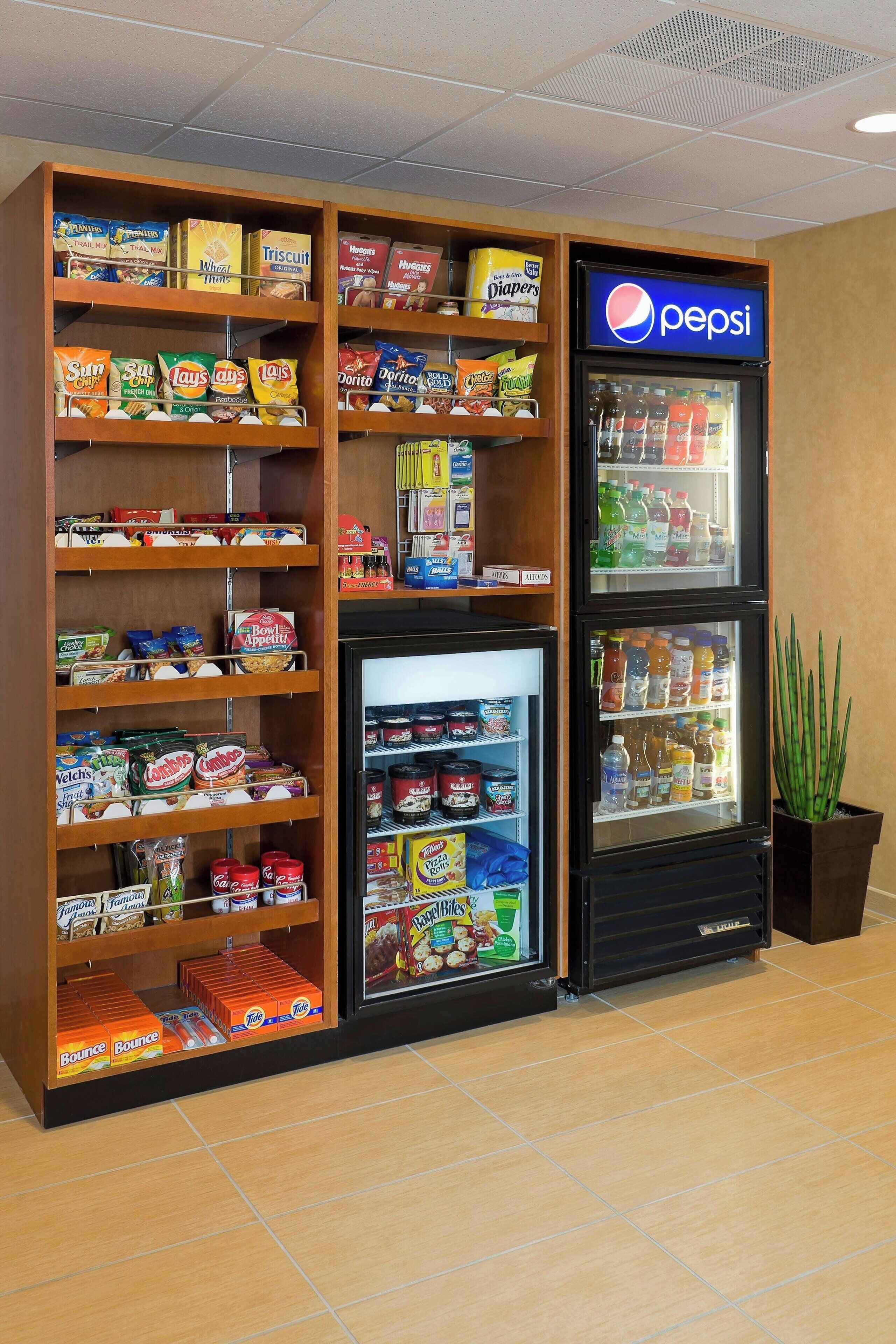 A vending machine stocked with snacks and beverages, including a Pepsi refrigerator.