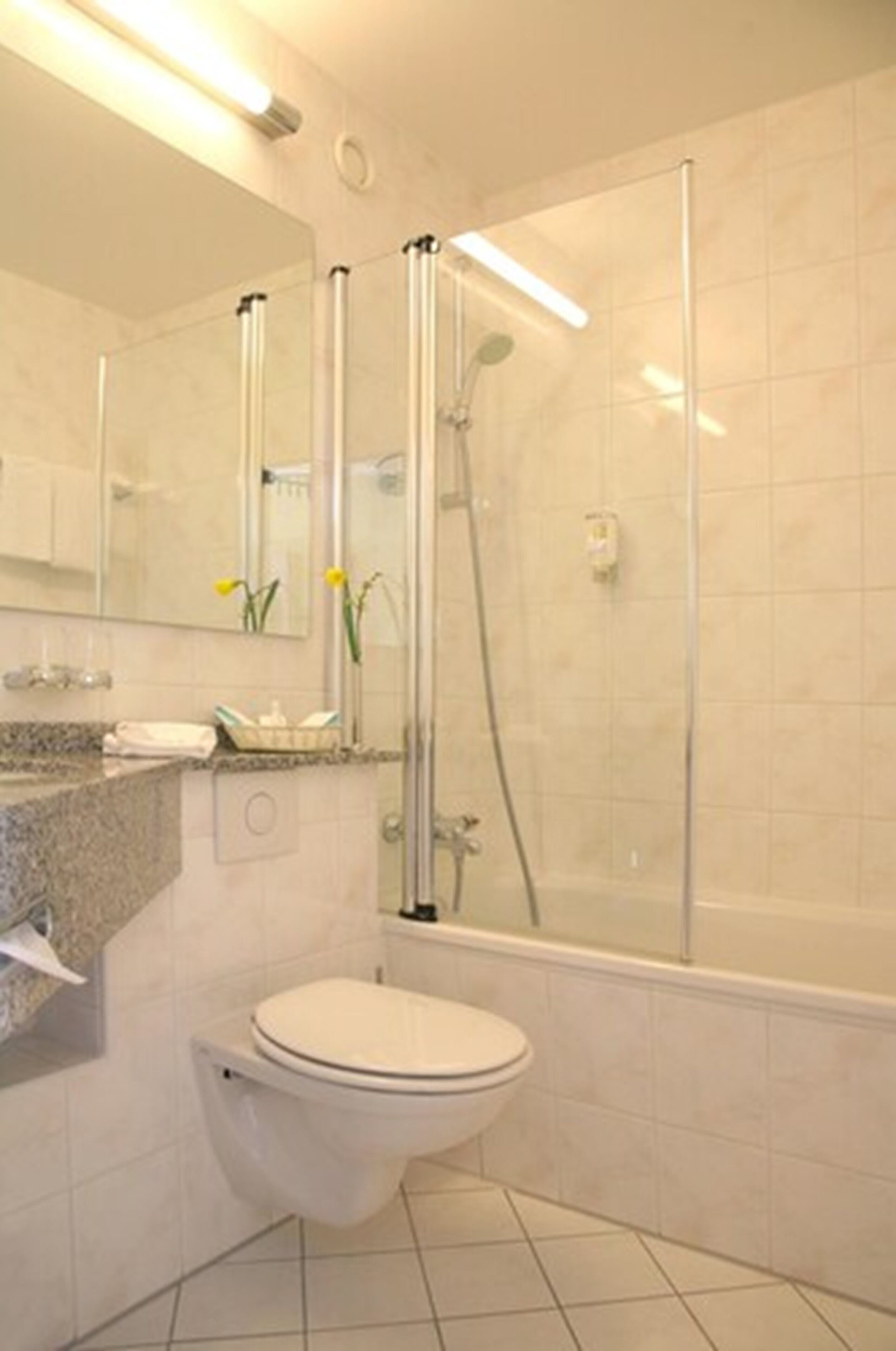 A modern bathroom with a toilet, sink, and shower.