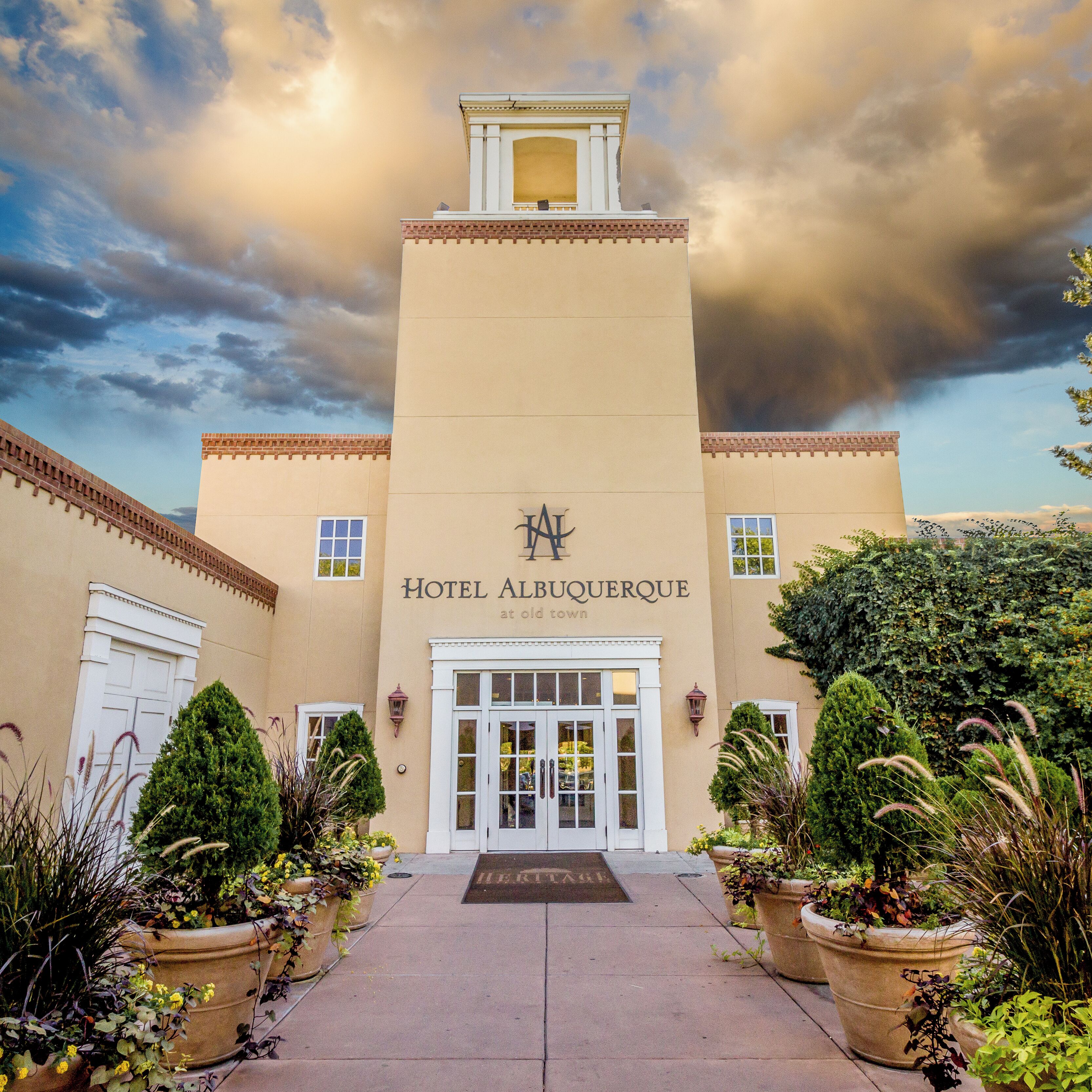 A hotel entrance with a sign reading 'Hotel Albuquerque,' a central entrance, and potted plants on either side.