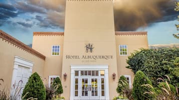 Entrada de hotel con un cartel que dice 'Hotel Albuquerque', una entrada principal y plantas en macetas a ambos lados.