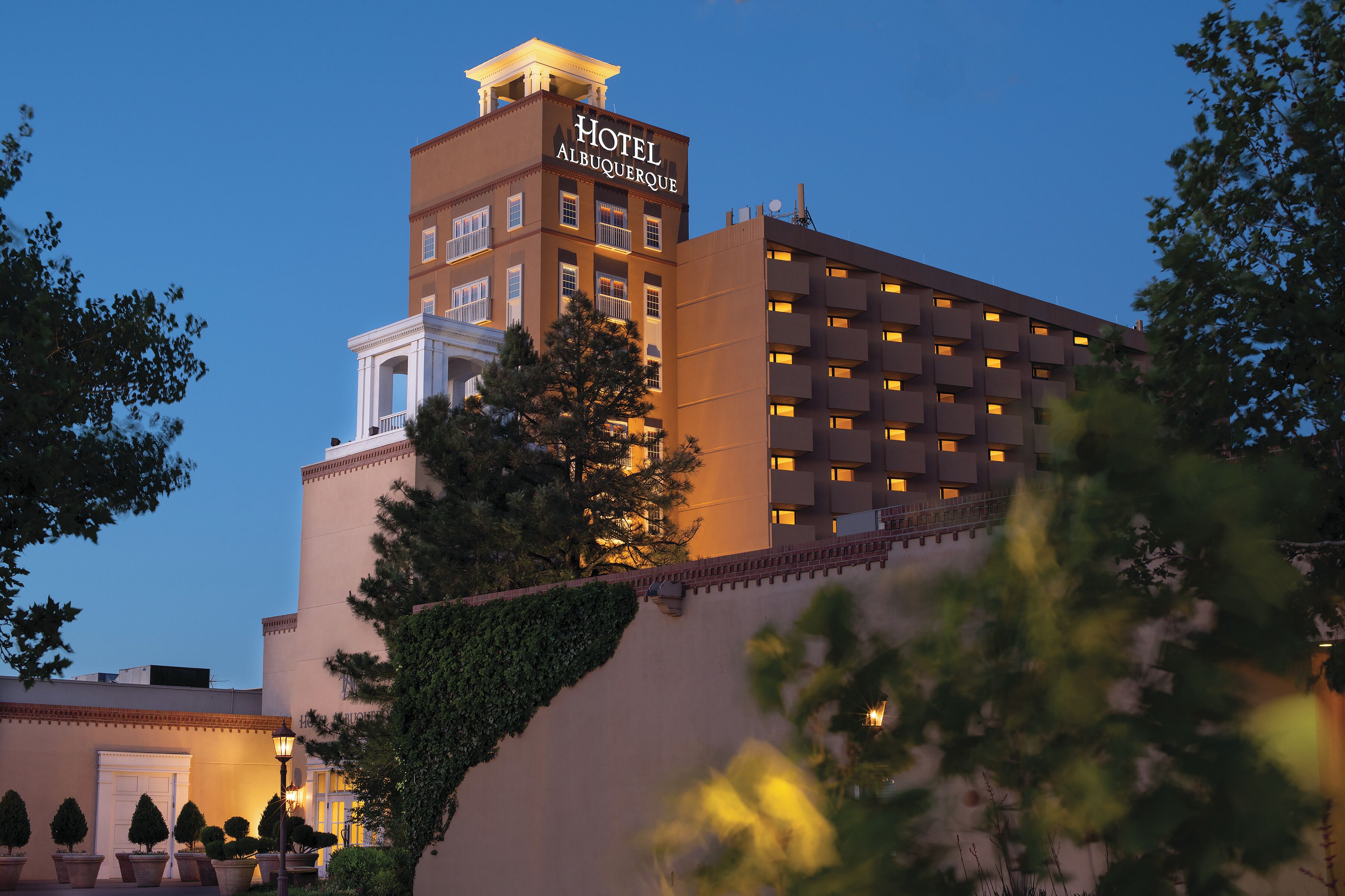A hotel with a prominent sign, multiple balconies, and a well-lit facade.