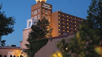 A hotel with a prominent sign, multiple balconies, and a well-lit facade.