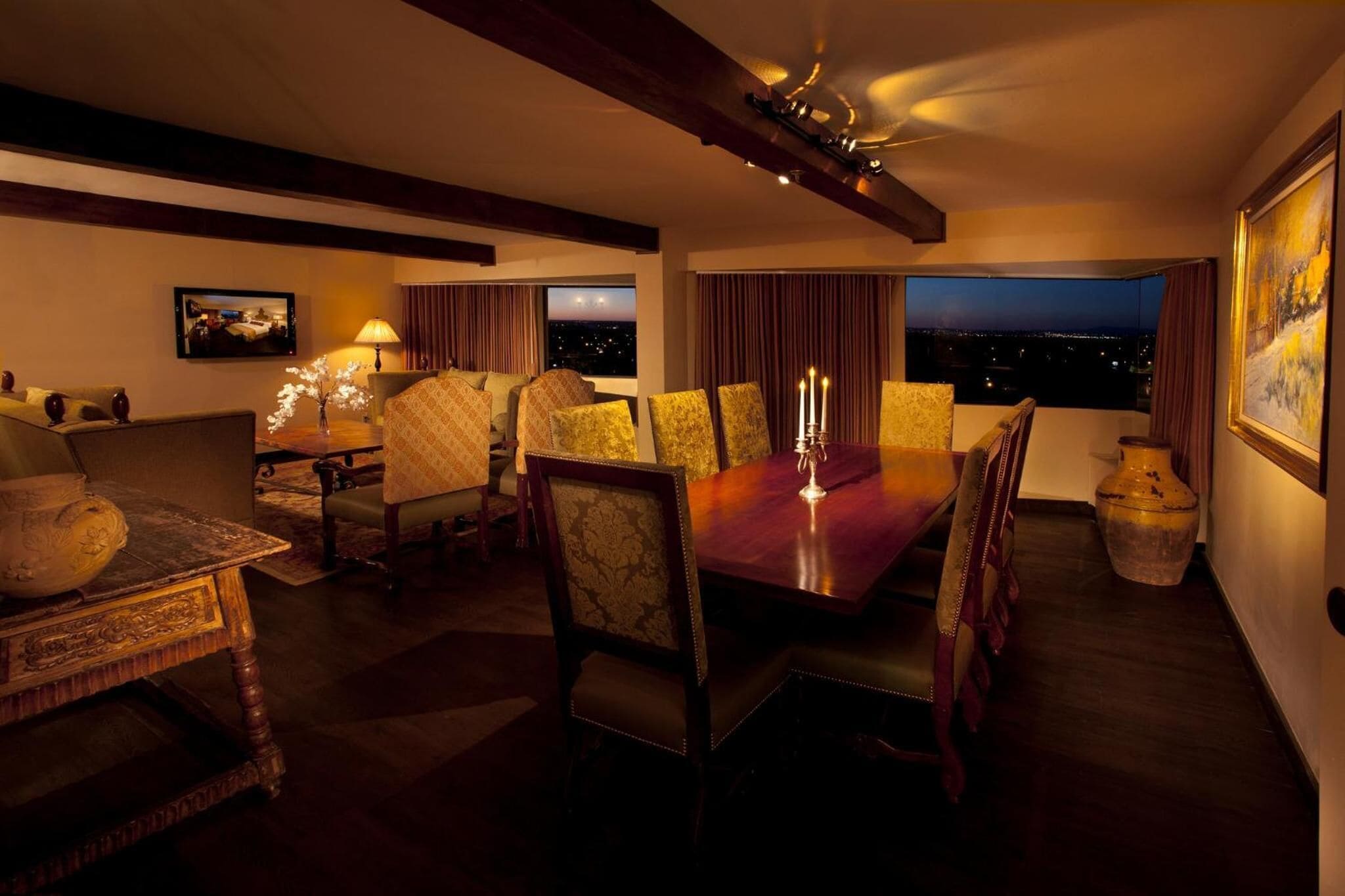 A dining area with a wooden table, patterned chairs, and a candle centerpiece.