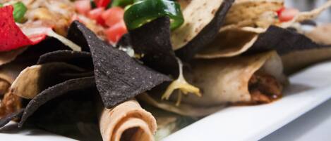 A plate of nachos with tortilla chips, cheese, and toppings.