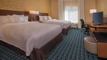 A hotel room with two beds, a desk with a computer, and a chair.