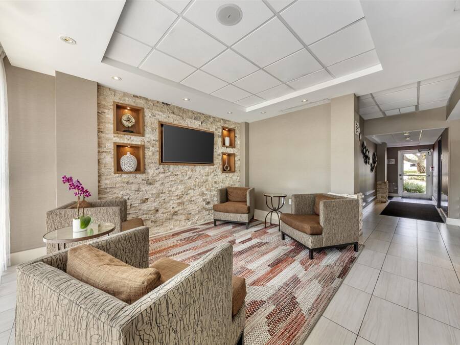 Una sala de estar moderna con una pared de acento de piedra, un televisor de pantalla plana y asientos cómodos.