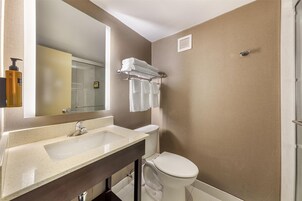 Et badeværelse med en beige vask, et hvidt toilet og en håndklædestang.