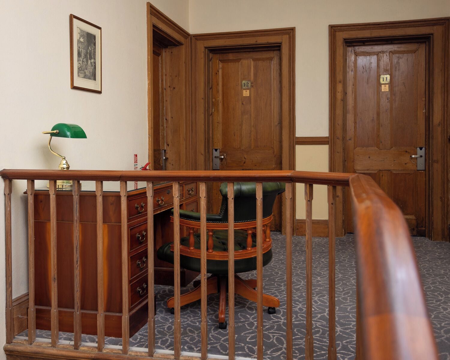 Une pièce comprenant un bureau, une chaise et deux portes en bois.