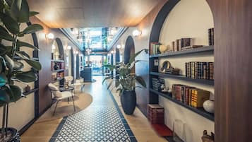 A cozy library with bookshelves, a patterned rug, and comfortable seating.