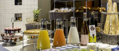 A buffet with various food items, including fruits, cheeses, and breads.