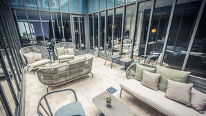 A modern outdoor seating area with wicker furniture, a sofa, and a coffee table. - Best Western Premier Hotel de la Poste & Spa (Troyes)