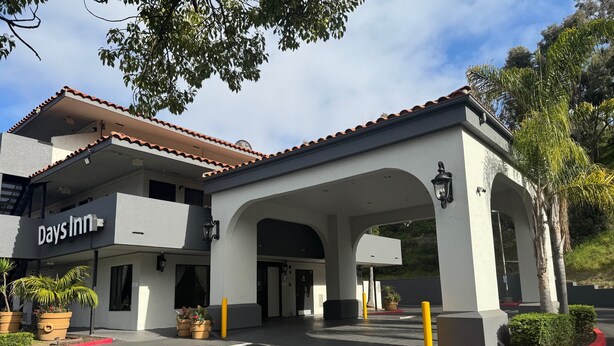 A Days Inn with a white facade, red-tiled roof, and a covered entrance.