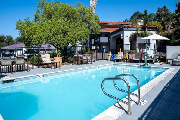 Una piscina al aire libre, sillones reclinables de piscina