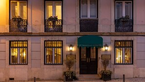 A building with a pink facade, multiple windows with green awnings, and a cobblestone ground. - As Janelas Verdes Inn, a Lisbon Heritage Collection (Lisbon)