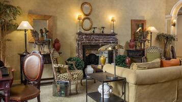 Una sala de estar acogedora con chimenea, asientos cómodos y lámparas decorativas.