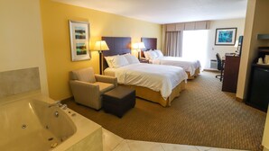 A hotel room with two beds, a sofa, a desk, a chair, and a bathtub. - Holiday Inn Express St. Ignace-Lake Front by IHG (St Ignace)