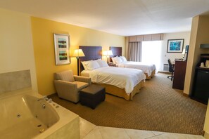 A hotel room with two beds, a sofa, a desk, a chair, and a bathtub. - Holiday Inn Express St. Ignace-Lake Front by IHG (St Ignace)