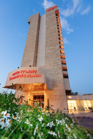 Un edificio alto con un letrero llamativo que dice "Leonardo Plaza".