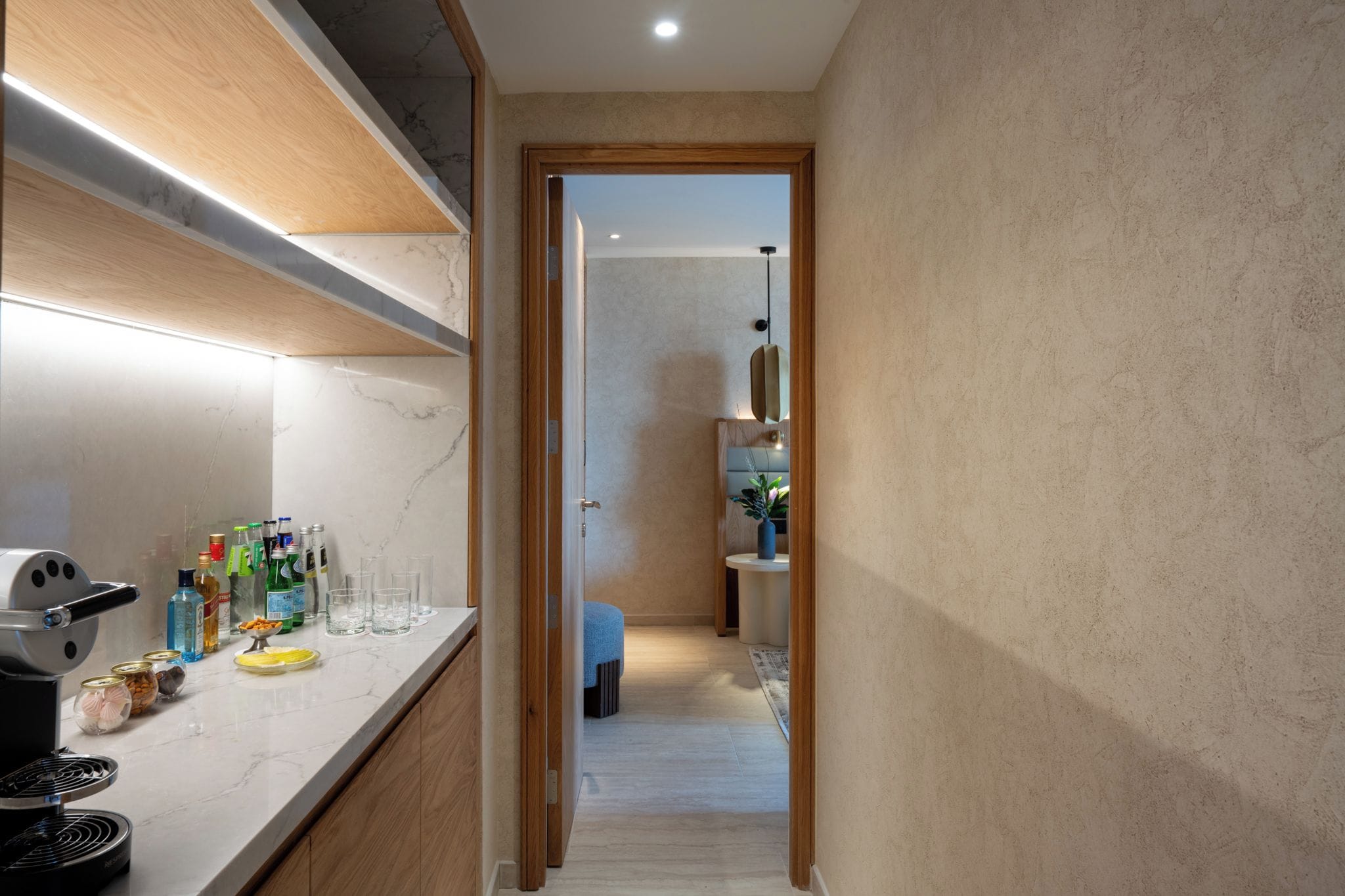 A modern kitchen with a marble countertop, a built-in grill, and various kitchen items.